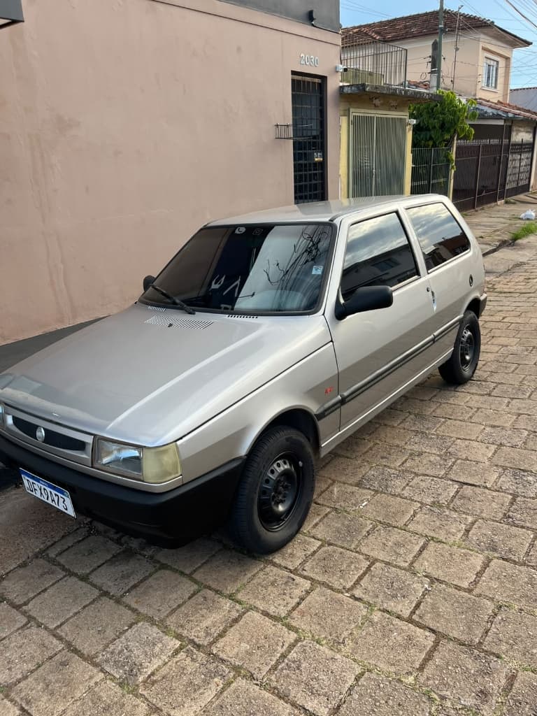 Fiat Uno Mille Fire 1.0 2002 prata visto de frente em três quartos